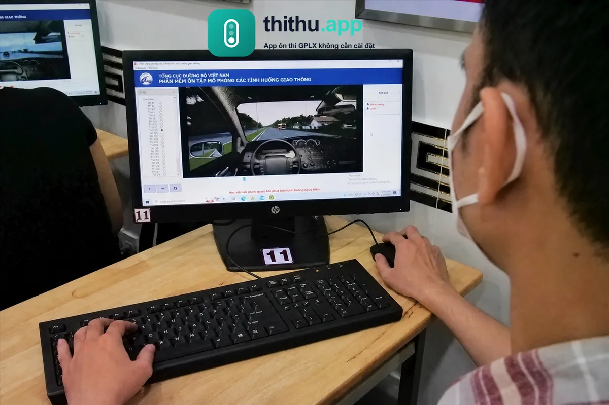 Học viên thi mô phỏng tình huống giao thông bằng video trên máy tính tại trung tâm đào tạo lái xe